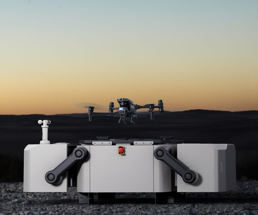 Eine Drohne schwebt über einer quadratischen, grauen Plattform bei Sonnenuntergang.